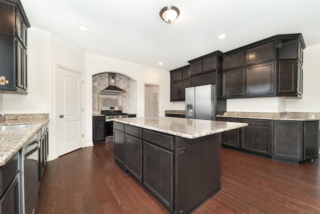 4215 Chandi Ct, Ypsilanti, MI 48197 - kitchen featuring stainless steel appliances, a kitchen island, wall chimney range hood, dark wood finished floors, and recessed lighting