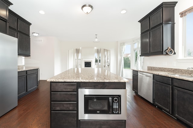 4215 Chandi Ct, Ypsilanti, MI 48197 - kitchen featuring stainless steel appliances, dark wood-style floors, light stone counters, recessed lighting, and a center island