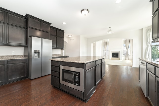 4215 Chandi Ct, Ypsilanti, MI 48197 - kitchen with appliances with stainless steel finishes, arched walkways, dark wood-type flooring, light stone counters, and recessed lighting