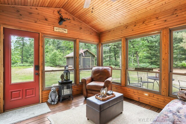 9228 S Star Lake Dr, Baldwin, MI 49304 - living area with a wood stove, lofted ceiling, wooden walls, hardwood / wood-style flooring, and wood ceiling