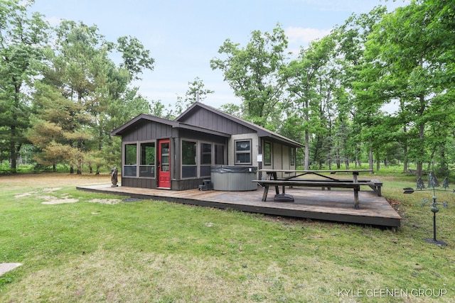 9228 S Star Lake Dr, Baldwin, MI 49304 - rear view of property featuring a hot tub, a wooden deck, and a lawn