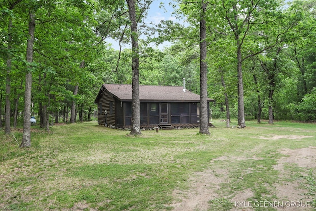 9210 S Star Lake Dr, Baldwin, MI 49304 - rear view of property with a sunroom, a lawn, and a shingled roof