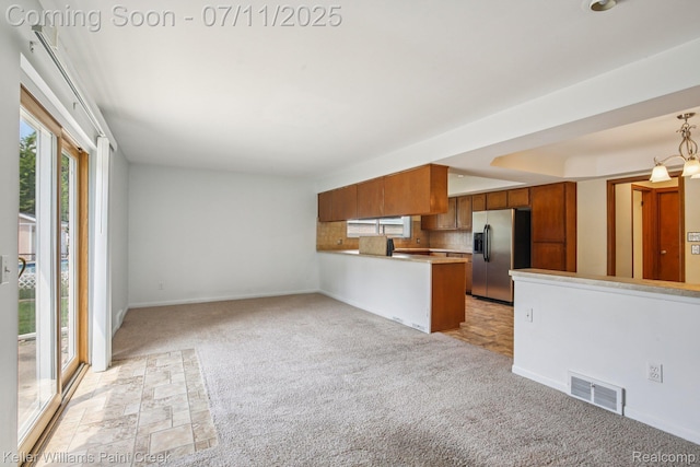 36819 Maas Dr, Sterling Heights, MI 48312 - kitchen with stainless steel fridge with ice dispenser, brown cabinets, healthy amount of natural light, and light colored carpet