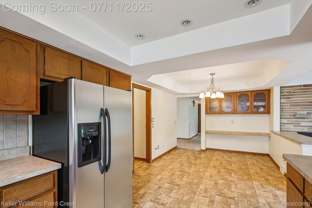 36819 Maas Dr, Sterling Heights, MI 48312 - kitchen with stainless steel refrigerator with ice dispenser, brown cabinets, a tray ceiling, backsplash, and a chandelier