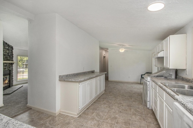 13114 Brockway Blvd, Vicksburg, MI 49097 - kitchen featuring ceiling fan, white appliances, a stone fireplace, white cabinets, and light countertops