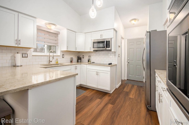 8477 Church Rd, Grosse Ile, MI 48138 - kitchen with stainless steel appliances, light stone counters, backsplash, dark wood-type flooring, and white cabinetry