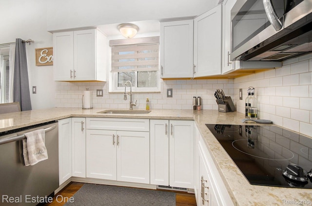 8477 Church Rd, Grosse Ile, MI 48138 - kitchen with appliances with stainless steel finishes, tasteful backsplash, white cabinets, and light stone countertops