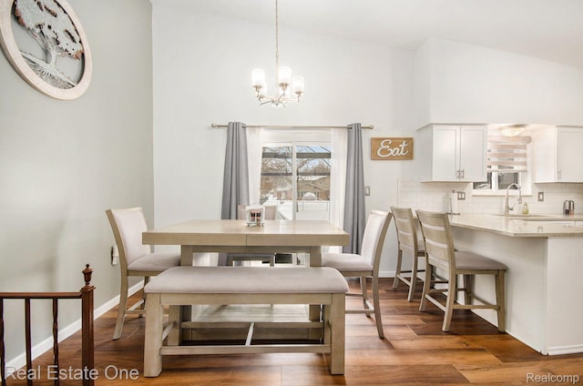 8477 Church Rd, Grosse Ile, MI 48138 - dining area featuring a chandelier, wood finished floors, and high vaulted ceiling