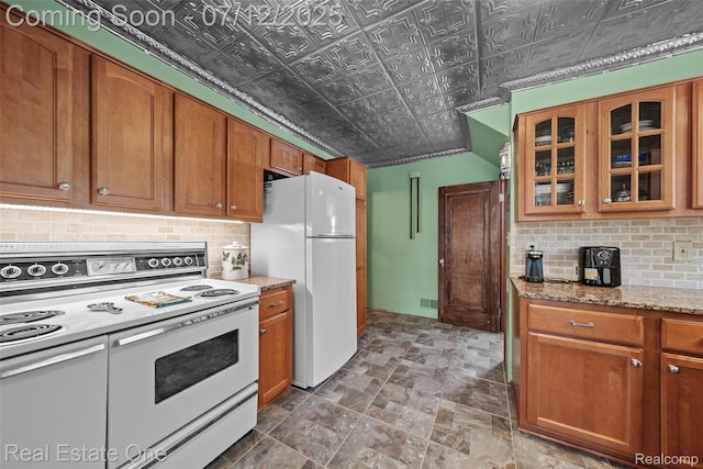 115 Illinois Ave, Pontiac, MI 48341 - kitchen with white appliances, an ornate ceiling, decorative backsplash, glass insert cabinets, and brown cabinetry