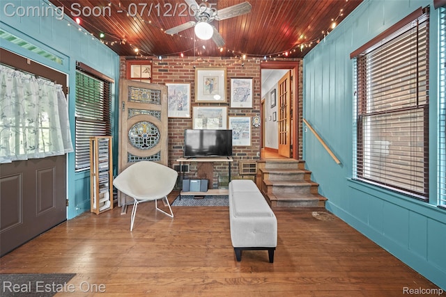 115 Illinois Ave, Pontiac, MI 48341 - sitting room featuring ceiling fan, wood finished floors, wood ceiling, a decorative wall, and stairs