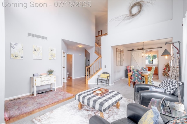 1884 Autumn Glen Dr, Howell, MI 48843 - living room with stairs, a chandelier, a high ceiling, and wood finished floors