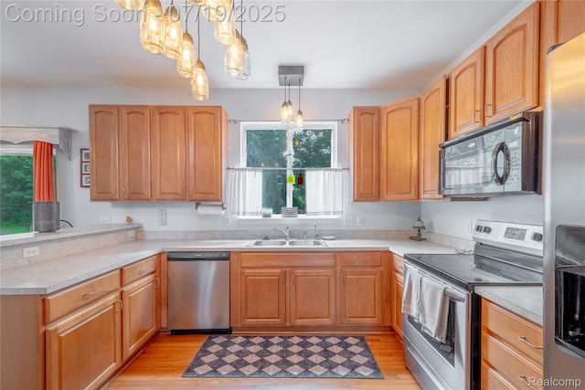1884 Autumn Glen Dr, Howell, MI 48843 - kitchen with stainless steel appliances, a peninsula, a chandelier, light wood-style flooring, and light countertops