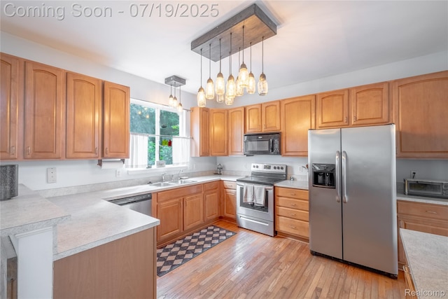 1884 Autumn Glen Dr, Howell, MI 48843 - kitchen featuring stainless steel appliances, light countertops, decorative light fixtures, and light wood-style flooring