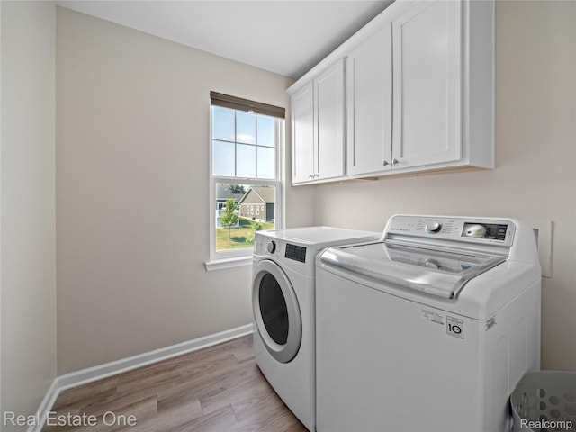 2838 Bogues View Dr, Howell, MI 48843 - washroom featuring washer and clothes dryer, cabinet space, and light wood-type flooring