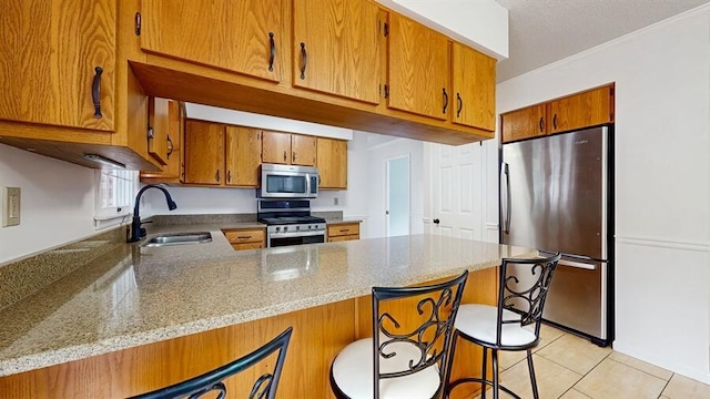 1330 Desmond St, Saint Joseph, MI 49085 - kitchen with appliances with stainless steel finishes, a peninsula, brown cabinets, and light tile patterned floors