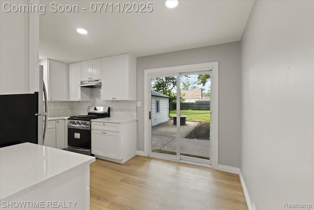 23041 Shakespeare Ave, Eastpointe, MI 48021 - kitchen with stainless steel range with gas stovetop, decorative backsplash, white cabinetry, under cabinet range hood, and light wood-style flooring