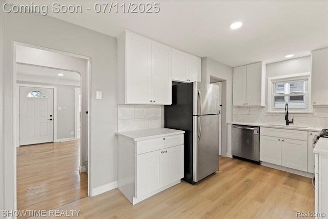 23041 Shakespeare Ave, Eastpointe, MI 48021 - kitchen with stainless steel appliances, light wood-style floors, tasteful backsplash, white cabinetry, and light countertops