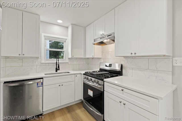 23041 Shakespeare Ave, Eastpointe, MI 48021 - kitchen featuring stainless steel appliances, under cabinet range hood, white cabinets, light wood-style flooring, and backsplash