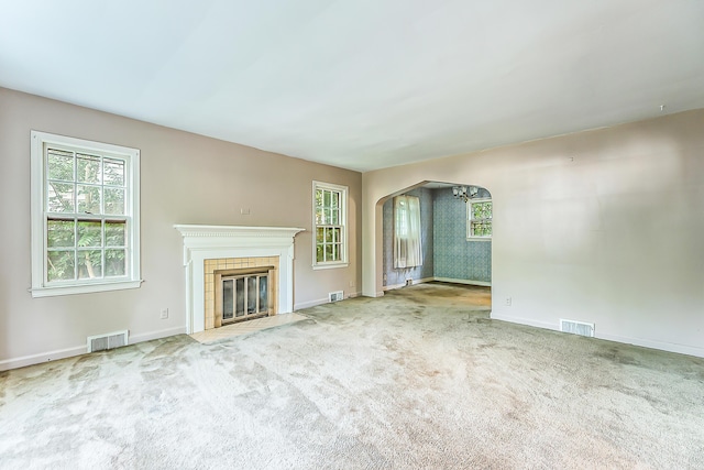 303 Wesley St, Ann Arbor, MI 48103 - unfurnished living room featuring arched walkways, carpet, and a fireplace