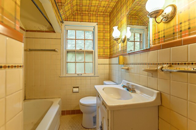 303 Wesley St, Ann Arbor, MI 48103 - bathroom with tile walls, a bathtub, wallpapered walls, vanity, and tile patterned floors