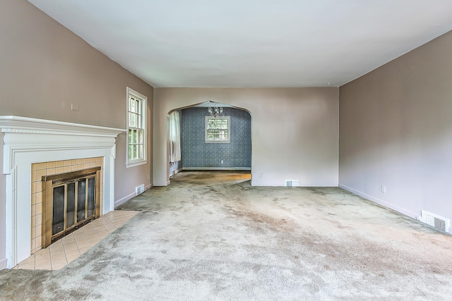 303 Wesley St, Ann Arbor, MI 48103 - unfurnished living room featuring arched walkways, carpet, and a fireplace