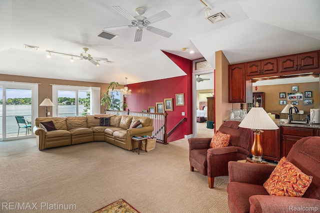 16344 Waterview Ln, Linden, MI 48451 - living room with rail lighting, light colored carpet, a ceiling fan, vaulted ceiling, and a chandelier
