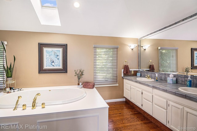 16344 Waterview Ln, Linden, MI 48451 - full bathroom with double vanity, a skylight, a garden tub, and wood finished floors