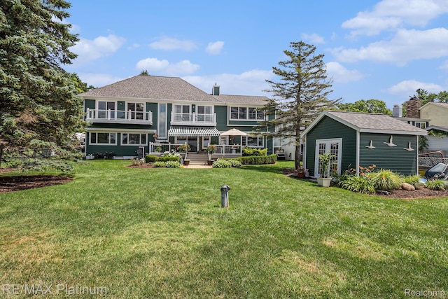 16344 Waterview Ln, Linden, MI 48451 - rear view of house featuring a chimney, an outdoor structure, and a lawn