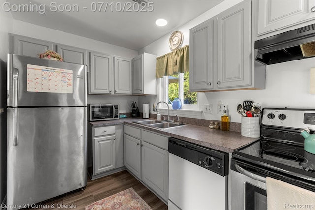 23486 Boller Ct, Trenton, MI 48183 - kitchen featuring appliances with stainless steel finishes, exhaust hood, dark wood finished floors, dark countertops, and recessed lighting