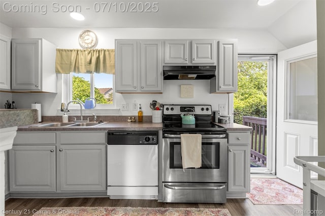 23486 Boller Ct, Trenton, MI 48183 - kitchen with dishwasher, stainless steel electric stove, exhaust hood, dark countertops, and dark wood-style flooring