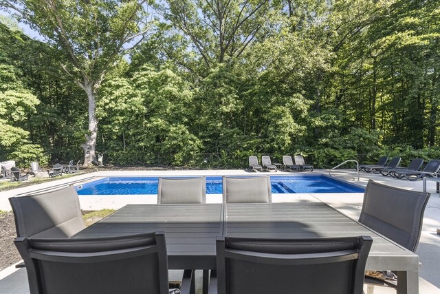 18734 Leonard Ct, New Buffalo, MI 49117 - swimming pool featuring a patio area, outdoor dining space, and view of wooded area