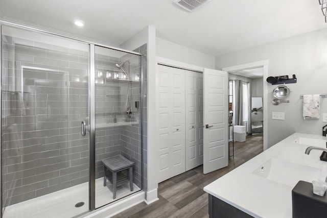 18734 Leonard Ct, New Buffalo, MI 49117 - full bathroom featuring a stall shower, wood finished floors, double vanity, and recessed lighting