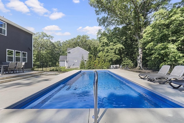 18734 Leonard Ct, New Buffalo, MI 49117 - swimming pool featuring a patio, view of wooded area, and outdoor dining area