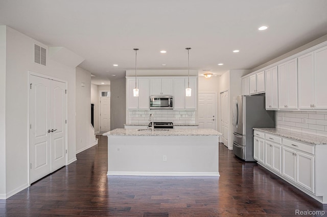 24727 Ivy Ln, Novi, MI 48375 - kitchen featuring appliances with stainless steel finishes, decorative backsplash, a center island with sink, white cabinetry, and recessed lighting