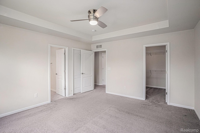 24727 Ivy Ln, Novi, MI 48375 - unfurnished bedroom with carpet floors, a walk in closet, ceiling fan, and a raised ceiling