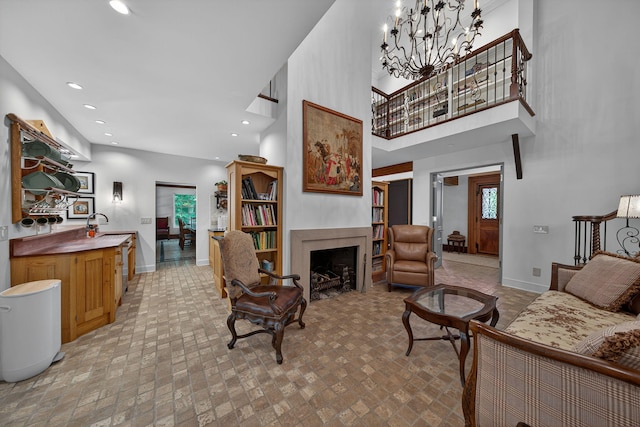 3420 Grange Rd, Berrien Springs, MI 49103 - living room with recessed lighting, a towering ceiling, brick patterned flooring, a fireplace, and a chandelier