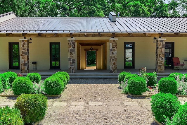 3420 Grange Rd, Berrien Springs, MI 49103 - view of exterior entry with a standing seam roof, stone siding, a porch, and a metal roof