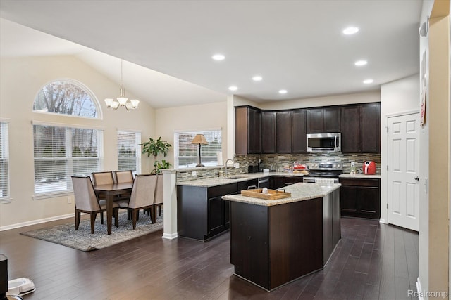 170 W Reed Lake Ct, Commerce Twp, MI 48390 - kitchen with stainless steel appliances, dark brown cabinets, decorative backsplash, a peninsula, and dark wood-style flooring