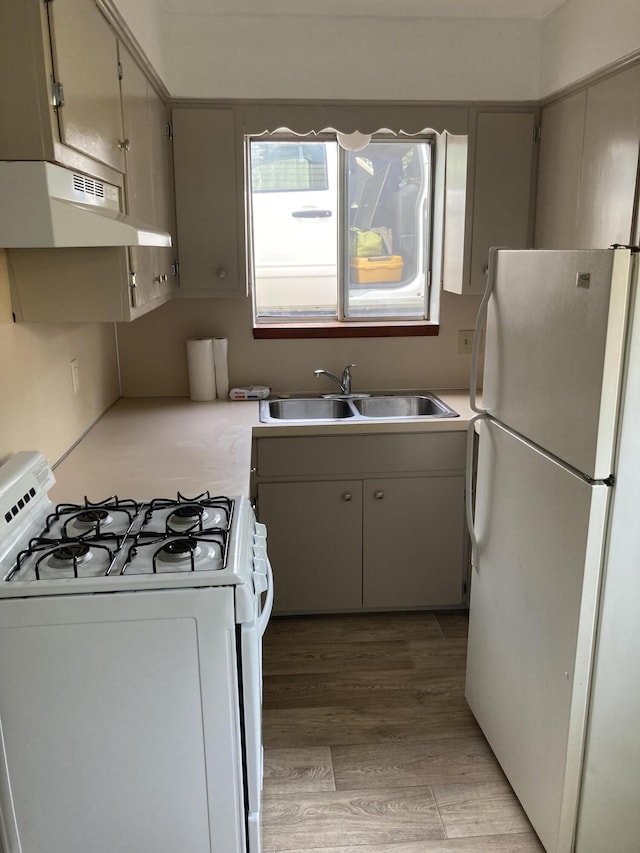 3607 Colby Ave SW, Wyoming, MI 49509 - kitchen featuring white appliances, under cabinet range hood, light countertops, and light wood finished floors
