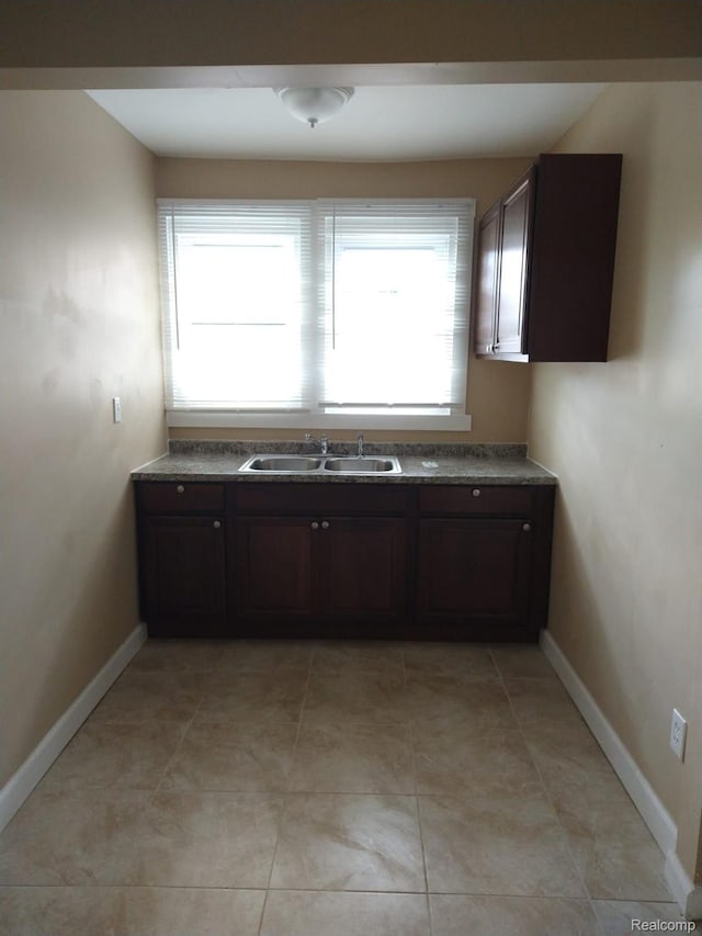 13340 Hartwell St, Detroit, MI 48227 - kitchen with plenty of natural light, dark countertops, dark brown cabinets, and light tile patterned floors