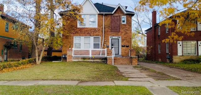 13340 Hartwell St, Detroit, MI 48227 - view of front of home with brick siding, a front lawn, and a porch