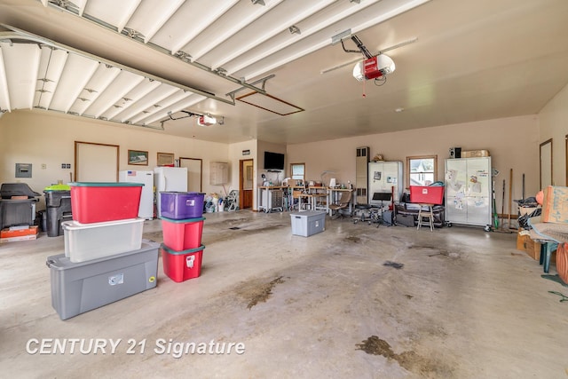 9610 Saginaw St, Reese, MI 48757 - garage with a garage door opener and freestanding refrigerator