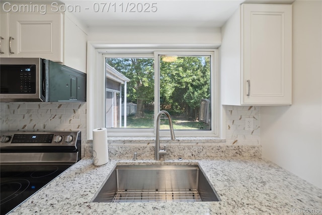 19190 Woodworth, Redford, MI 48240 - kitchen with stainless steel appliances, decorative backsplash, white cabinetry, and light stone countertops