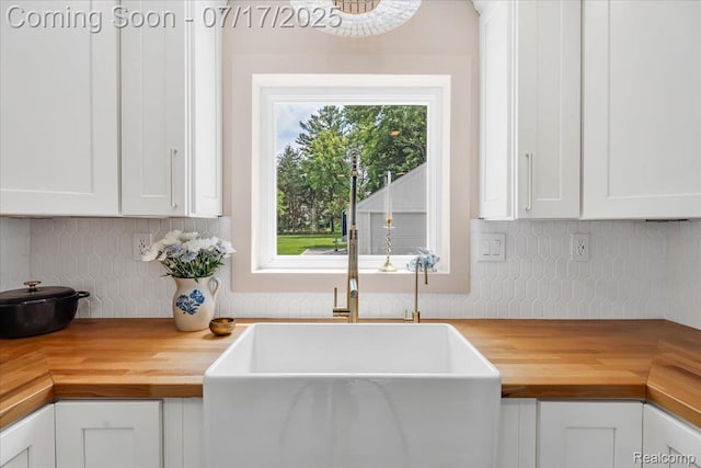 1133 Kingston Ave, Flint, MI 48507 - kitchen with butcher block countertops, backsplash, and white cabinets