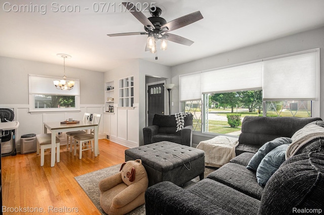 1510 S Harris Rd, Ypsilanti, MI 48198 - living room with a chandelier, light wood-type flooring, a ceiling fan, and a wainscoted wall