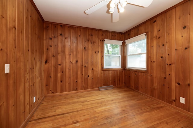 3026 Leigh Ave, Kalamazoo, MI 49048 - unfurnished room with light wood-style floors, a ceiling fan, and wooden walls