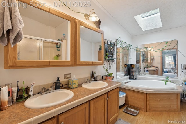 3410 Eastdale Dr, Flint, MI 48506 - bathroom featuring a skylight, a garden tub, double vanity, wood finished floors, and a shower stall