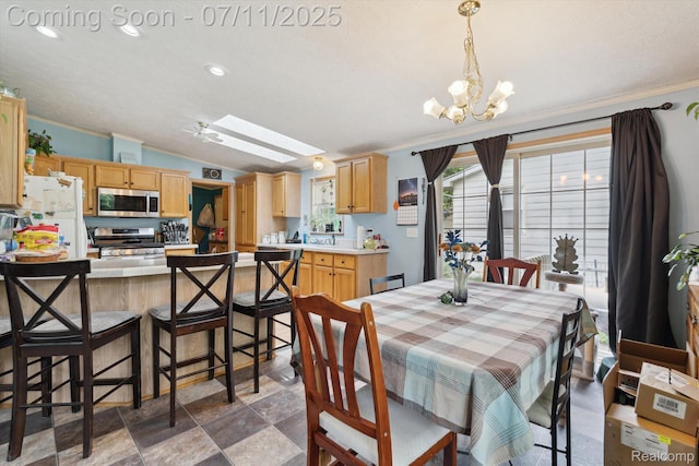 3410 Eastdale Dr, Flint, MI 48506 - dining space with lofted ceiling, crown molding, a chandelier, recessed lighting, and a skylight