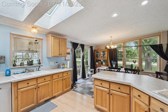 3410 Eastdale Dr, Flint, MI 48506 - kitchen featuring dishwasher, a textured ceiling, a chandelier, a skylight, and decorative light fixtures
