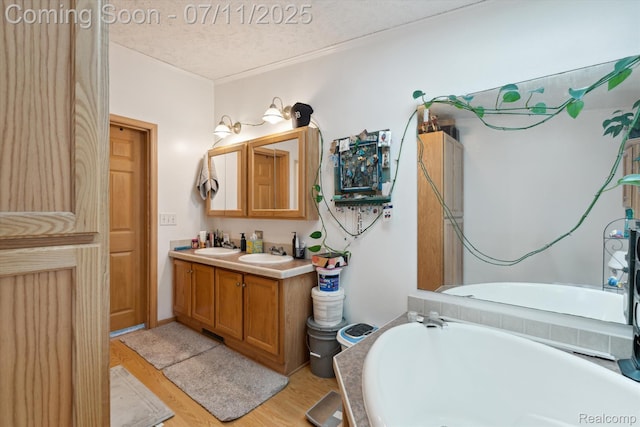 3410 Eastdale Dr, Flint, MI 48506 - full bathroom with a tub, double vanity, a textured ceiling, and wood finished floors